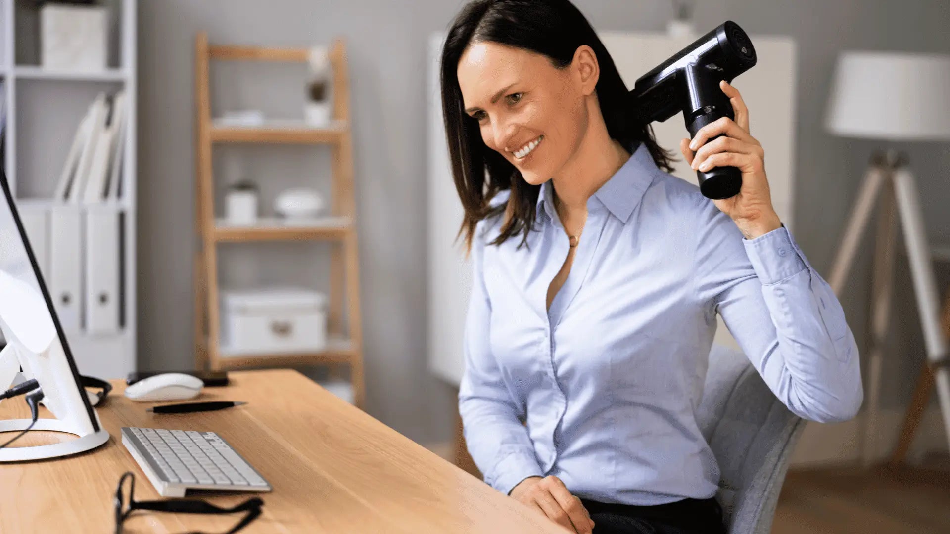 Woman using a massage gun to relieve muscle tension in an article about massage guns