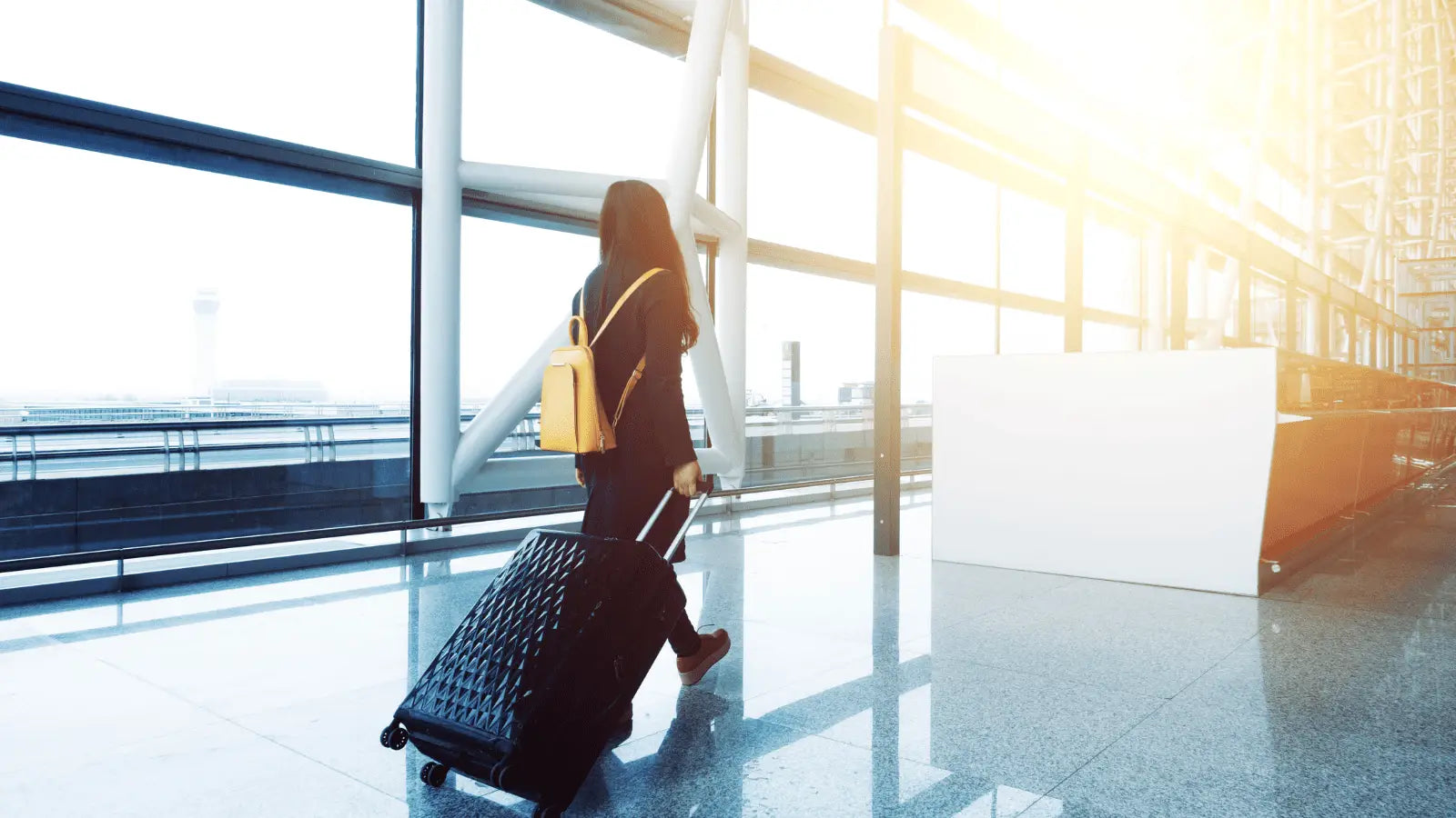 Black rolling suitcase with massage gun ready for travel with lithium-ion batteries
