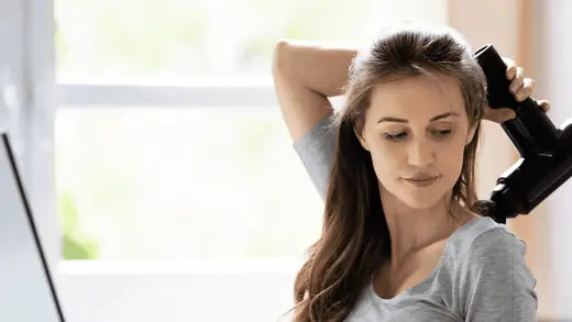 Woman using handheld vacuum for percussive therapy recovery