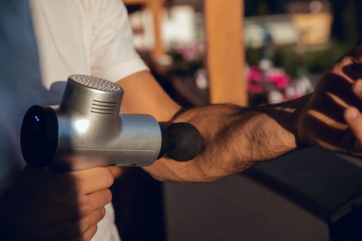 Silver massage gun for muscle knots therapy shown in Do massage guns work for knots article