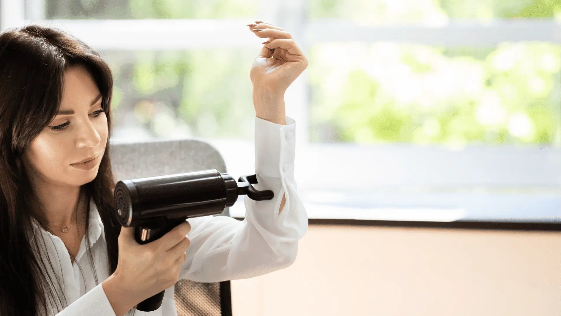 Woman using massage gun while considering charging time