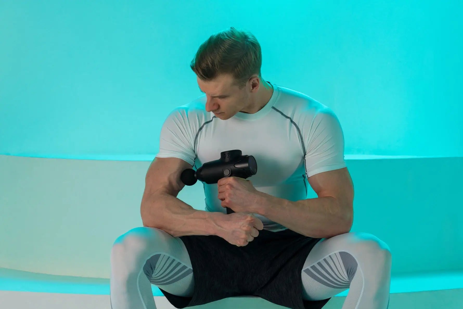 Man using massage gun for Draftkings massage benefits in an article on massage guns