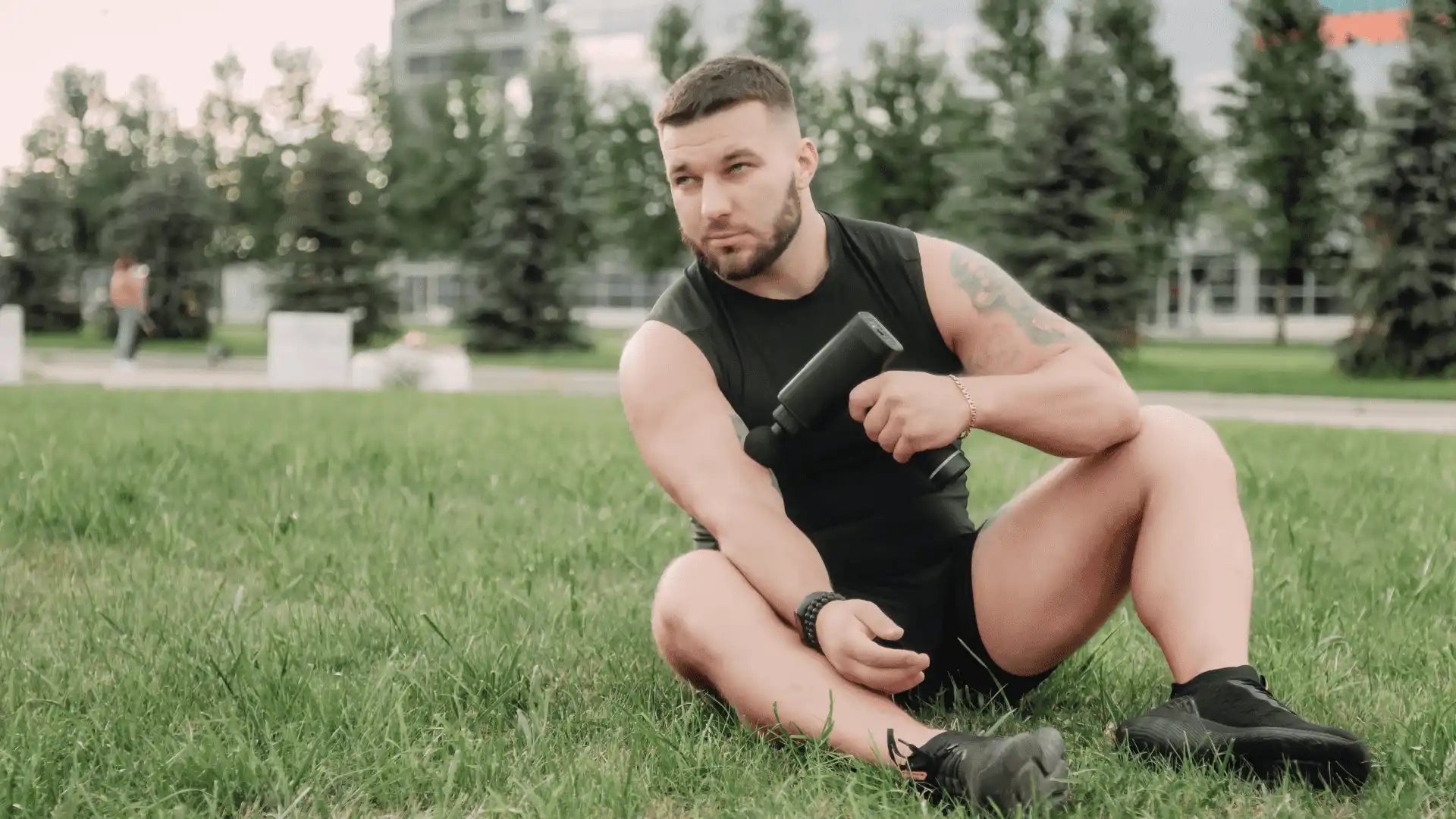 Black handheld massage gun targeting muscle groups to boost blood flow