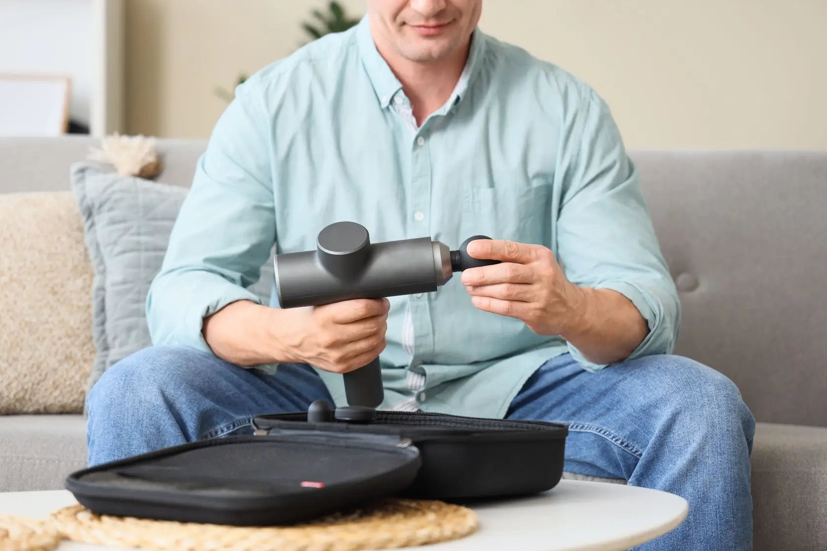 Gray massage gun with fully charged battery and power button ready to turn on