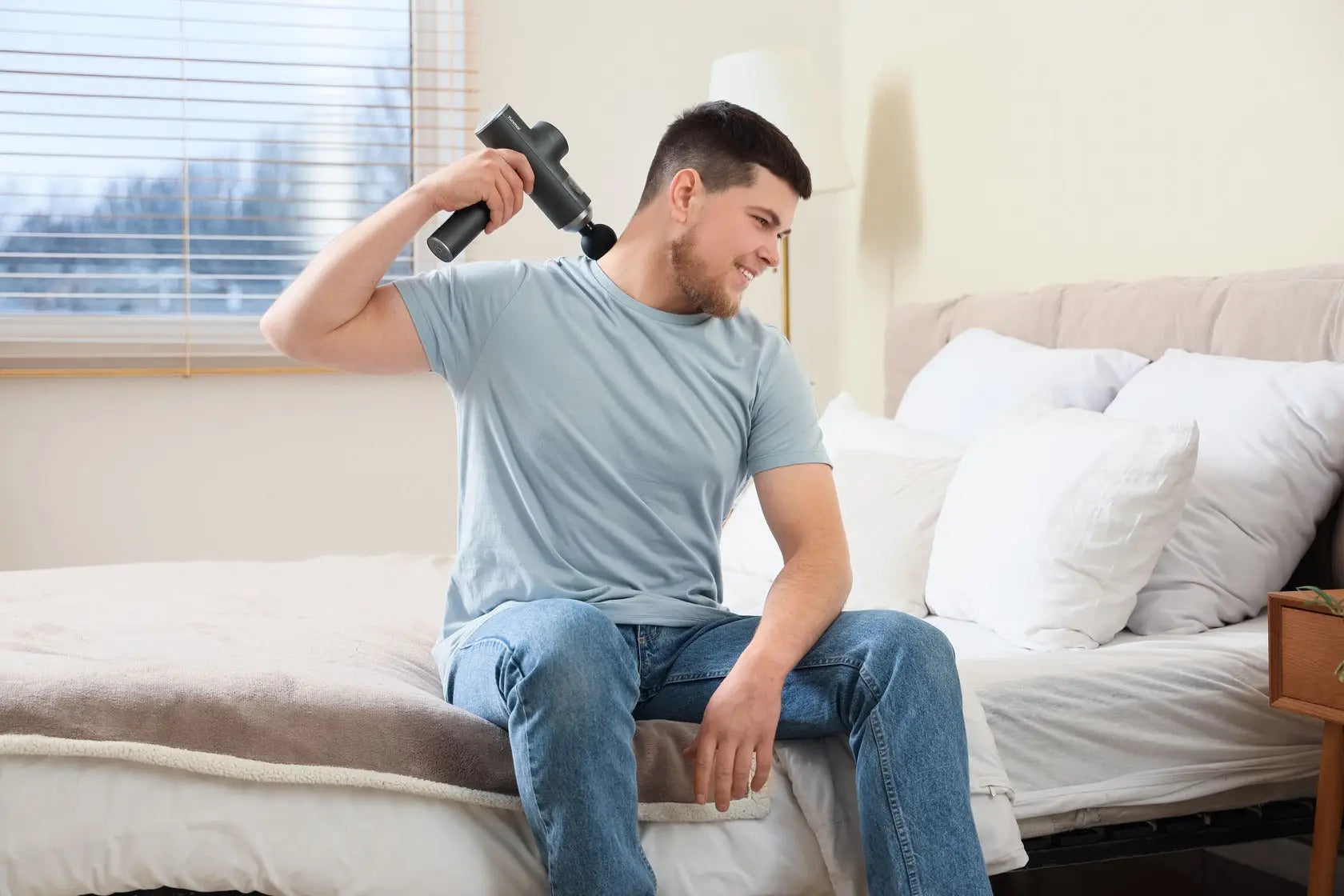 Man using massage gun to relieve back muscle soreness