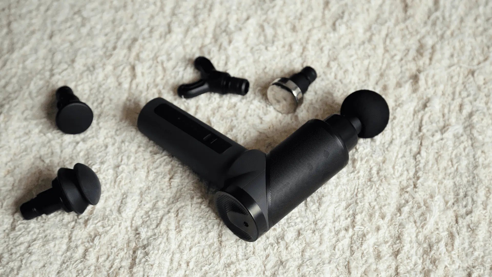 Black massage gun with attachments for therapy