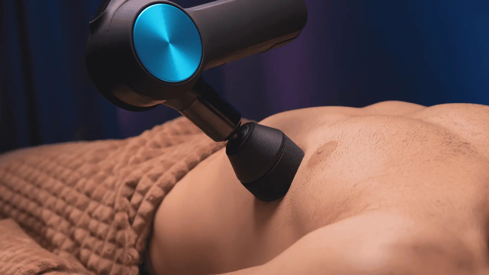 Massage gun used on muscular back for recovery during rest days with massage guns