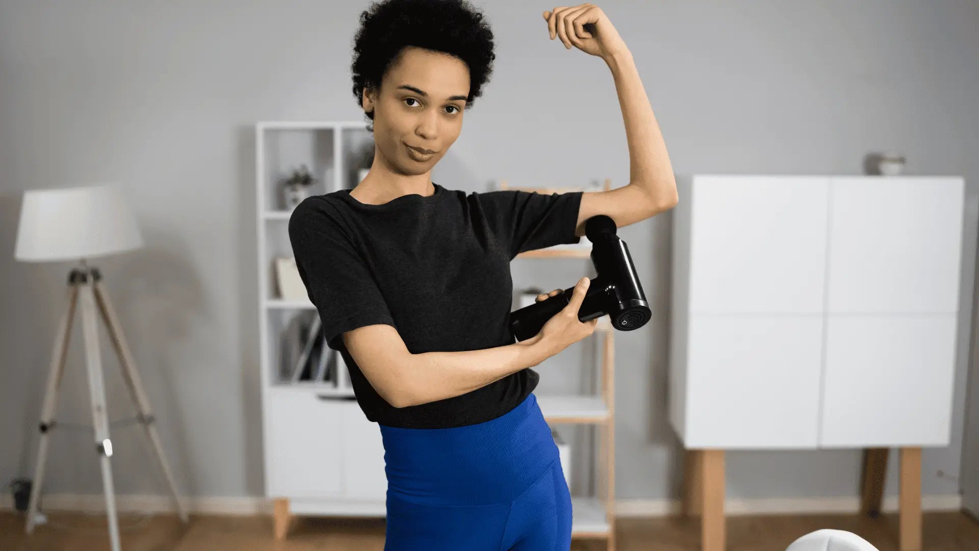 Woman using massage gun for muscle recovery to improve flexibility and reduce soreness