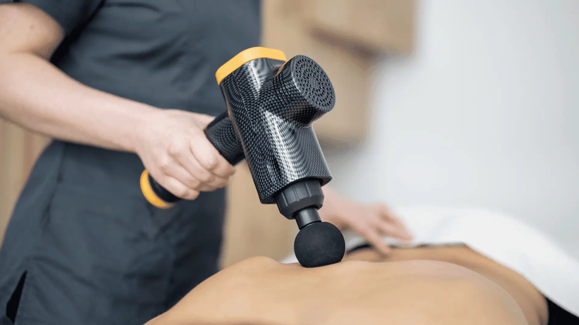 Massage gun being used on back for muscle relief in article about where to buy massage guns
