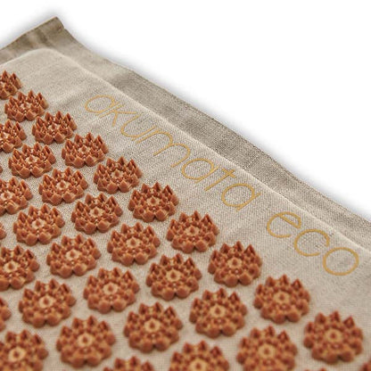 Light-colored brown acupressure mat with spiky lotus-shaped discs for relaxation and pain relief