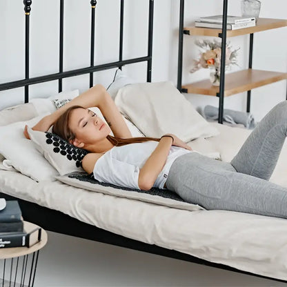 Woman on gray textured cooling mat with black acupressure mat Akumata