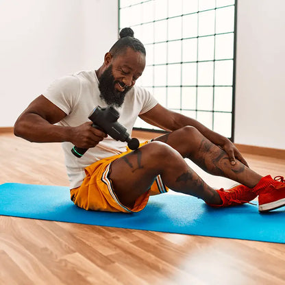 Man using percussion massage gun for muscle recovery and sore muscles relaxation